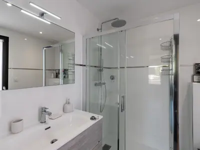 a white bathroom with a shower and a sink at Apartment Domaine d'Arca-1 by Interhome in Porto-Vecchio