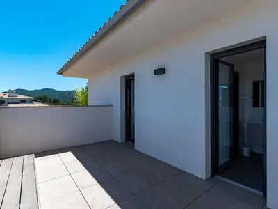 a white house with a large glass door at Apartment Domaine d'Arca-1 by Interhome in Porto-Vecchio