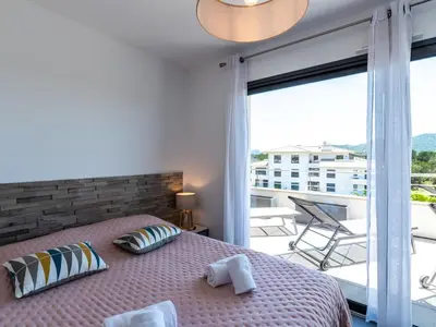 a bedroom with a bed and a large window at Apartment Domaine d'Arca-1 by Interhome in Porto-Vecchio