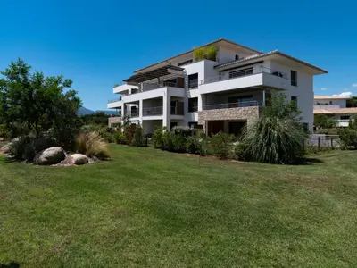 a large white building with a yard in front of it at Apartment Domaine d'Arca-1 by Interhome in Porto-Vecchio