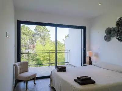 a bedroom with two beds and a mirror at Apartment Les Jardins d'Ève- F3 by Interhome in Favone