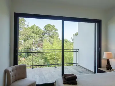 two beds in a room with a large window at Apartment Les Jardins d'Ève- F3 by Interhome in Favone