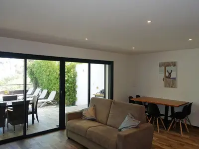 a living room with a couch and a table at Apartment Les Jardins d'Ève- F3 by Interhome in Favone