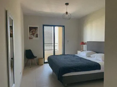 a bedroom with a large bed with two towels on it at Appartement spacieux 6 personnes sur le vieux port in Porto-Vecchio