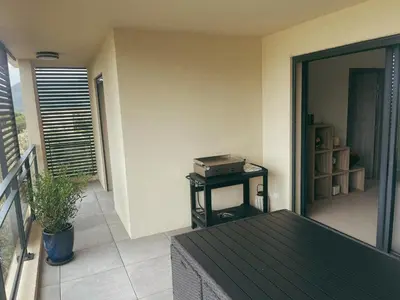a balcony with a table with a suitcase on it at Appartement spacieux 6 personnes sur le vieux port in Porto-Vecchio