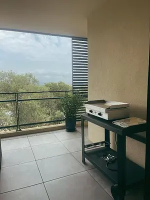 a view of a balcony with a stove on a table at Appartement spacieux 6 personnes sur le vieux port in Porto-Vecchio