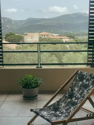 a chair sitting on a balcony with a view at Appartement spacieux 6 personnes sur le vieux port in Porto-Vecchio