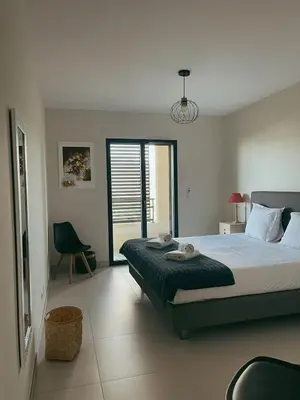 a bedroom with a bed and a bathroom with a toilet at Appartement spacieux 6 personnes sur le vieux port in Porto-Vecchio