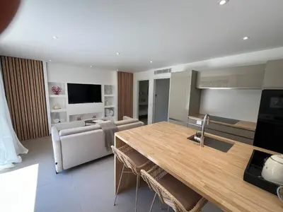 a kitchen and living room with a large wooden table at Perla Bianca in Bonifacio