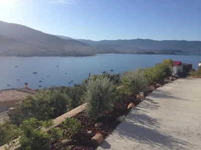 a view of a large body of water with bushes at Rez de villa, vue panoramique mer et montagne ! in Vico
