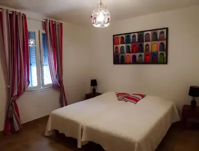 a bedroom with a bed and a painting on the wall at Villa avec vue sur la mer à Sari-Solenzara, piscine privée in Sari Solenzara