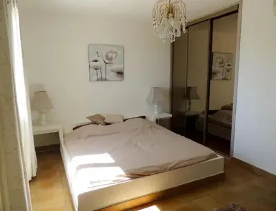 a white bedroom with a bed and a chandelier at Villa avec vue sur la mer à Sari-Solenzara, piscine privée in Sari Solenzara