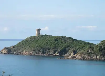 an island in the water with a lighthouse on it at Villa avec vue sur la mer à Sari-Solenzara, piscine privée in Sari Solenzara