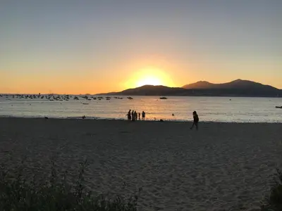 a group of people walking on the beach at sunset at Bella Vista 42, T2 vue mer piscine Porticcio in Porticcio