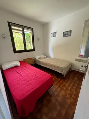 a bedroom with two beds and a red blanket at Bella Vista 42, T2 vue mer piscine Porticcio in Porticcio