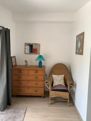 a bedroom with a chair and a dresser with a mirror at Chambre indépendante dans villa bord de mer in Vico
