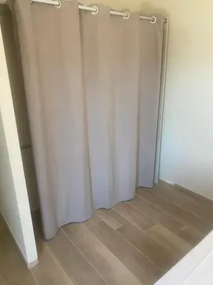 a closet with white curtains and a wooden floor at Casa Missia in Porto-Vecchio