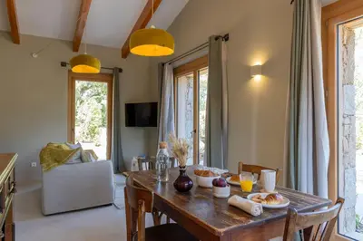 a dining room with a wooden table with food on it at Hameau de Petripini in Sotta