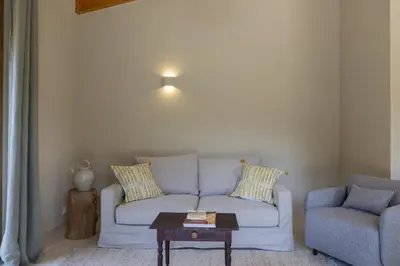 a living room with a couch and a chair and a table at Hameau de Petripini in Sotta
