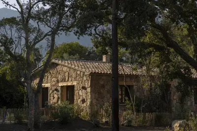 a stone house with trees in front of it at Hameau de Petripini in Sotta