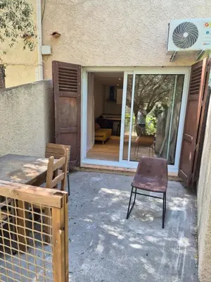 a chair sitting outside of a building with a patio at Studio dans résidence calme in Porto-Vecchio
