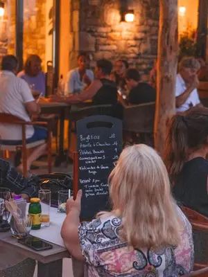 a woman sitting at a table in a restaurant at Domaine Santa Margherita in Castellare-di-Casinca