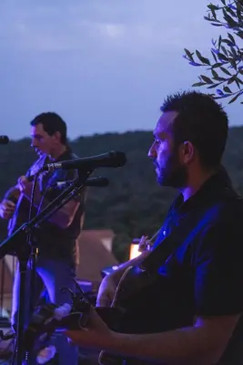 two men sitting at a microphone in front of a crowd at Domaine Santa Margherita in Castellare-di-Casinca