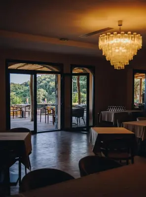 a dining room with tables and chairs and a chandelier at Domaine Santa Margherita in Castellare-di-Casinca