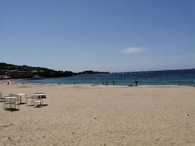 a beach with chairs and people in the water at Olmeto 10 mn plage App 5-6P in Olmeto