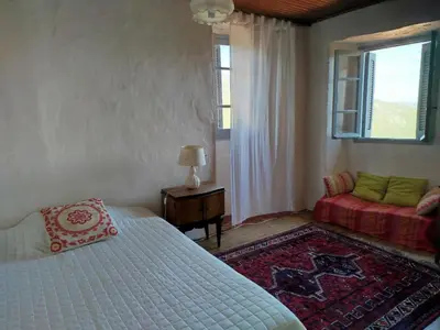 a bedroom with a bed and a table and a chair at Olmeto 10 mn plage App 5-6P in Olmeto