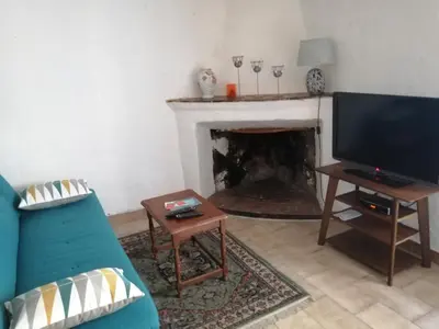 a dining room with a wooden table and chairs at 10mn des plages - Olmeto village App 4P in Olmeto