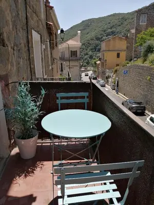 a table and two chairs on a balcony with a table at 10mn des plages - Olmeto village App 4P in Olmeto