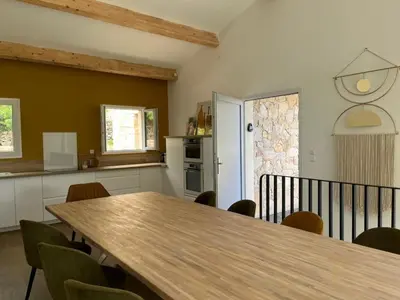 a kitchen with a wooden table and chairs at La Villa di Paraso in Ville-di-Paraso