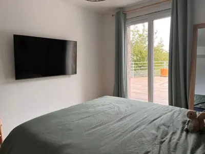 a bedroom with a bed with a television on the wall at La Villa di Paraso in Ville-di-Paraso