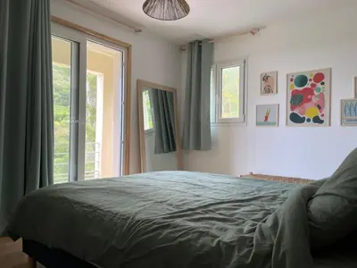 a bedroom with a bed and a large window at La Villa di Paraso in Ville-di-Paraso