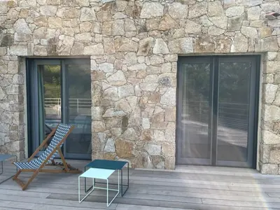 a patio with a bench and a stone wall at La Villa di Paraso in Ville-di-Paraso