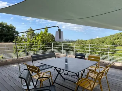 a patio with a table and chairs on a deck at La Villa di Paraso in Ville-di-Paraso