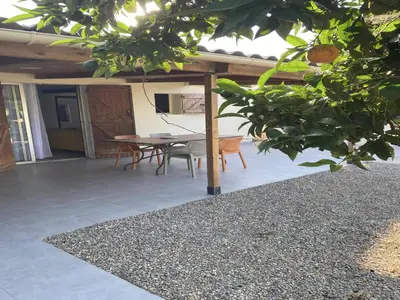 a patio with a table and chairs under a roof at A casetta di l alivu in Lucciana