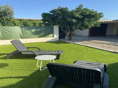 a lawn with two chairs and a table on it at A casetta di l alivu in Lucciana