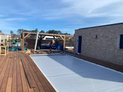 a man standing next to a swimming pool on a deck at Villa standing Arciquadra Porto Vecchio in Lecci