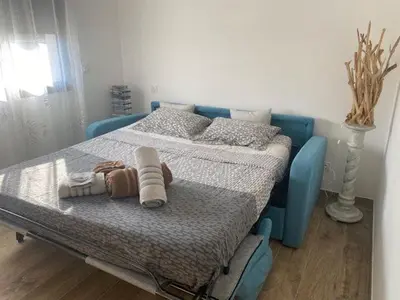 a bedroom with a blue bed with towels on it at Villa standing Arciquadra Porto Vecchio in Lecci