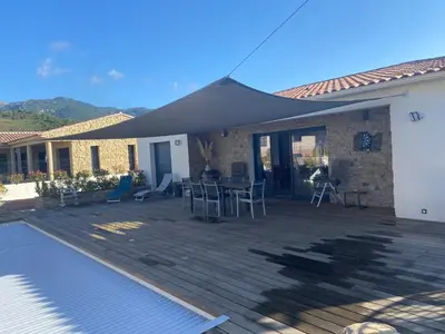 a patio with awning and a table and chairs at Villa standing Arciquadra Porto Vecchio in Lecci