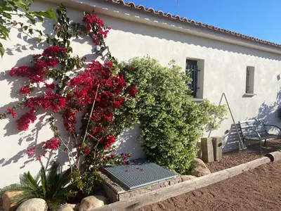 a house with red flowers on the side of it at Villa standing Arciquadra Porto Vecchio in Lecci
