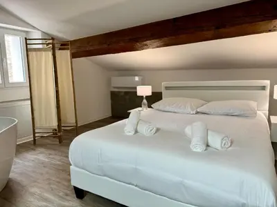 a bedroom with a large white bed with white pillows at Chambre de charme à Evisa in Evisa