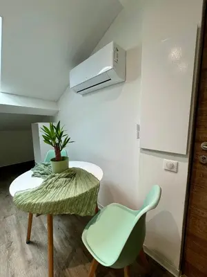 a small room with a table and a green chair at Chambre de charme à Evisa in Evisa