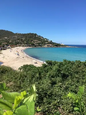 a beach with people on the sand and the water at Appartement MAEVA duplex vue mer à Favone in Conca