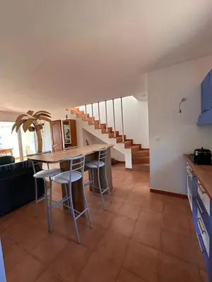 a kitchen with a table and chairs and stairs at Appartement MAEVA duplex vue mer à Favone in Conca