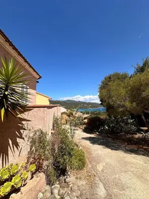 a garden with a house and trees and a road at Appartement MAEVA duplex vue mer à Favone in Conca