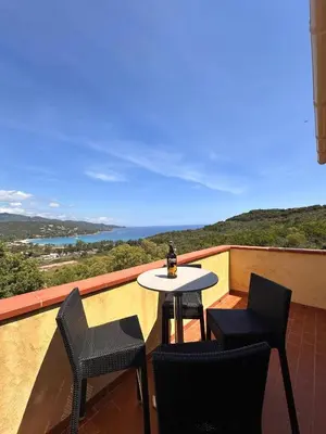 a table and chairs on a balcony with a view at Appartement MAEVA duplex vue mer à Favone in Conca