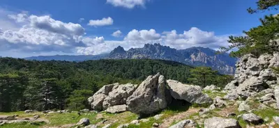 a view of a mountain range with rocks and trees at BandB les rosiers - chambre Eglantine in Conca